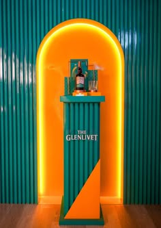 a green and yellow bar with a bottle on it's shelf in front of a wall