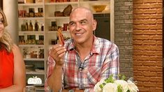 a man and woman sitting at a table with food in front of them on tv