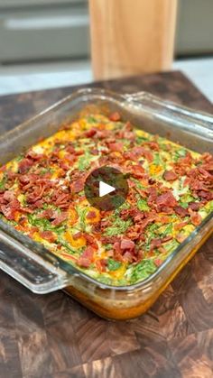 a glass casserole dish on a wooden table with a video player in the background