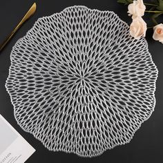 a white doily sitting on top of a table next to flowers and a pair of scissors