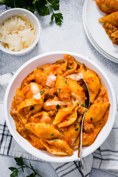 a white bowl filled with pasta and meat