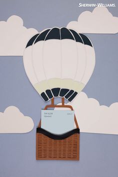 a hot air balloon cutout on the side of a wall with clouds in the background