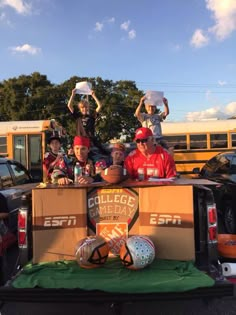 some people are sitting in the back of a truck with balls and basketballs on it