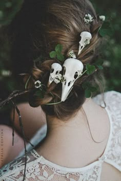 a woman with flowers in her hair and skulls on the back of her head,