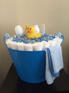 a blue tub filled with lots of diapers and a rubber ducky in it