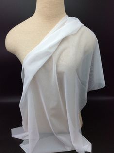 a mannequin wearing a white draped top