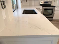 a kitchen with white marble counter tops and stainless steel appliances