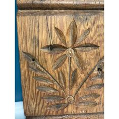 an old wooden carving with flowers and leaves on it