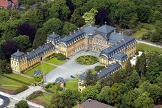 an aerial view of a large mansion surrounded by trees