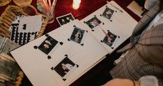 a table topped with papers and pictures on top of each other next to a vase filled with flowers