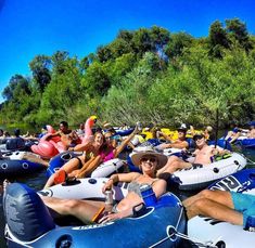 a group of people riding in rafts down a river with paddle boats on the water