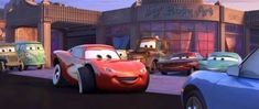 cars lined up on the street in front of a building with characters from disney and pixa