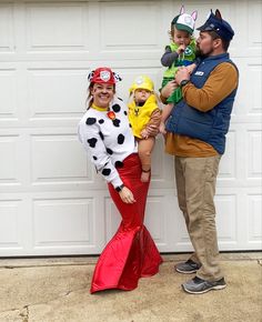 a man, woman and child dressed up in costumes standing next to a garage door