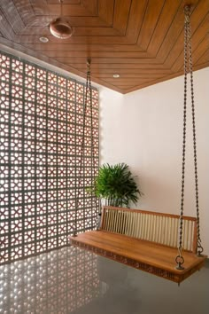 a wooden bench sitting next to a plant in a room