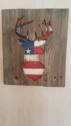 an american flag deer head mounted on a wooden wall with birds perched on the antlers