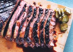 sliced up steak on a cutting board with pickles