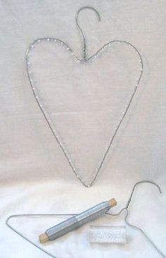 a heart shaped object with a string attached to it and two batteries on the ground