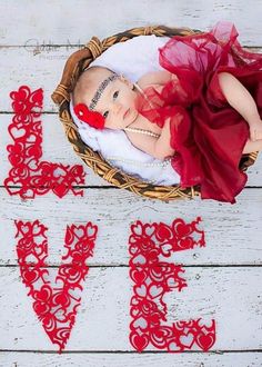 a baby in a basket with the word love spelled out