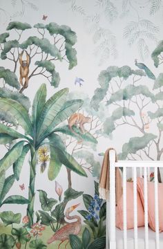 a baby's crib in front of a jungle mural