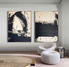 two black and white paintings hang on the wall above a round chair in a living room