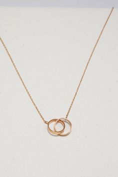 ITEM INFO This exquisite piece, featuring a pair of interlocked rings on a delicate round chain, symbolizes connection and harmony in a chic, minimalist design. Perfect for those who appreciate the beauty of simplicity and the warmth of rose gold, here's why this necklace is a must-have addition to your collection: Symbolic Elegance: The interlocked rings represent the unbreakable bonds of love and friendship, making this necklace not just a piece of jewelry, but a meaningful symbol. Premium Quality: Crafted from 14K solid rose gold, this necklace boasts durability and a timeless luster that elevates any outfit. Delicate Design: The sleek round chain, measuring 16 inches, ensures the double rings charm sits gracefully at the base of the neck, perfect for both everyday wear and special occa Interlocked Rings, Rose Gold Jewelry Necklace, Double Rings, Love And Friendship, Rings Necklace, Gold Jewelry Necklace, Hypoallergenic Jewelry, Delicate Design, Double Ring