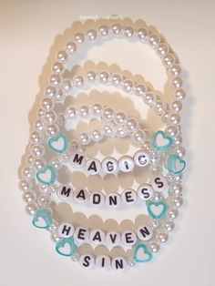 three bracelets with words on them and hearts in the shape of letters that spell magic, madness, heaven, sin