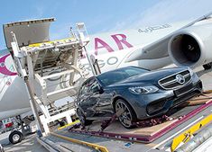 a car being loaded onto an airplane on the tarmac