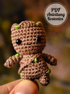 a tiny crocheted teddy bear with green eyes