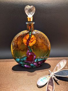 a glass bottle sitting on top of a table next to a dragonfly ornament