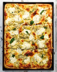 a square pizza topped with artichoke and cheese