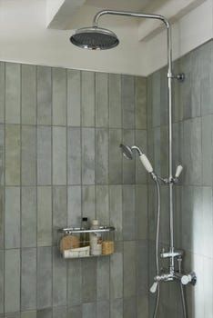 a shower head and hand held shower faucet in a bathroom with tiled walls