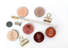 several magnets with different types of flowers on them and a pencil in the middle