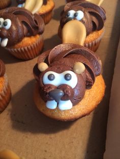 some cupcakes with chocolate frosting and icing on them are decorated like dogs