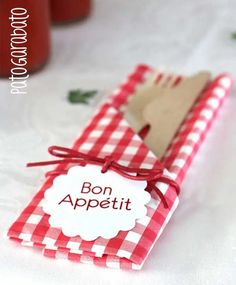 a red and white checkered napkin with a wooden spoon on it that says bon appetit