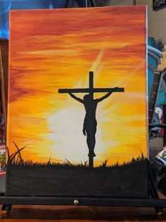 a painting of a person with a cross in front of an orange and yellow sunset