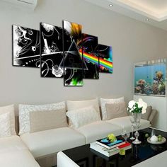 a living room with white couches and paintings on the wall