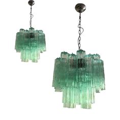 two green glass chandeliers hanging from chains