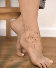 a woman's foot with a small tattoo on the side of her leg,