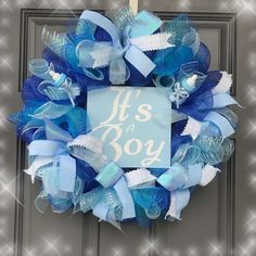 a blue wreath with it's a boy sign hanging on the front door to say it's a boy