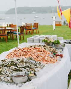 an assortment of seafood is displayed on a table with chairs and tables in the background