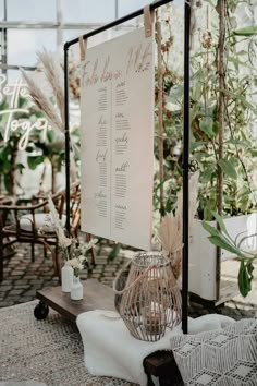 the seating plan is displayed on a sign in front of chairs and tables with plants