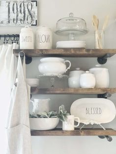 the shelves are filled with dishes and other kitchen items, such as glassware on them