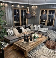 a living room filled with lots of furniture and pillows on top of a wooden floor