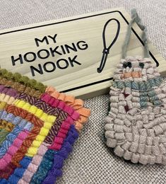 a pair of knitted slippers sitting next to a sign that says, my hooking nook