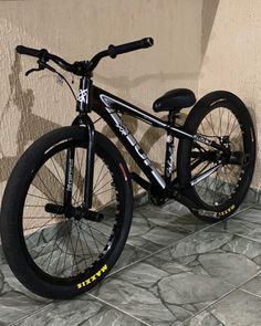 a black and white bike parked next to a wall