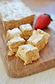 some food is sitting on a cutting board next to a strawberries and other foods