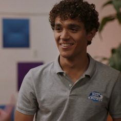 a young man smiling and wearing a polo shirt