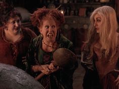 three women dressed as witches standing next to each other