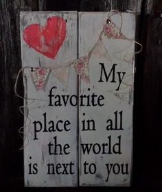 two wooden signs that say, my favorite place in all the world is next to you