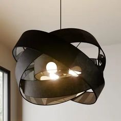 an unusual light fixture hanging from the ceiling in a room with white walls and windows